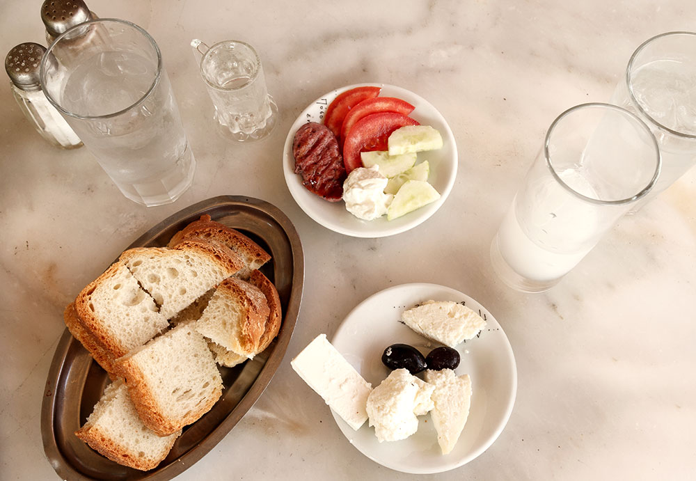 Tisch mit Ouzo, Brot, Oliven, Käse und Tomaten - Table with ouzo, bread, olives, cheese and tomatoes